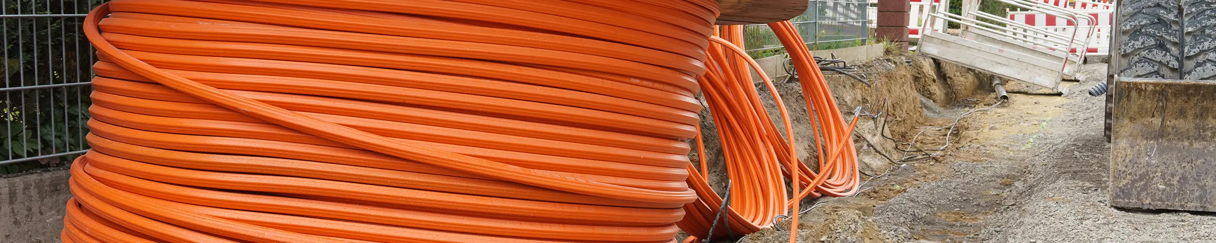 Orange fiber optic cable being buried underground